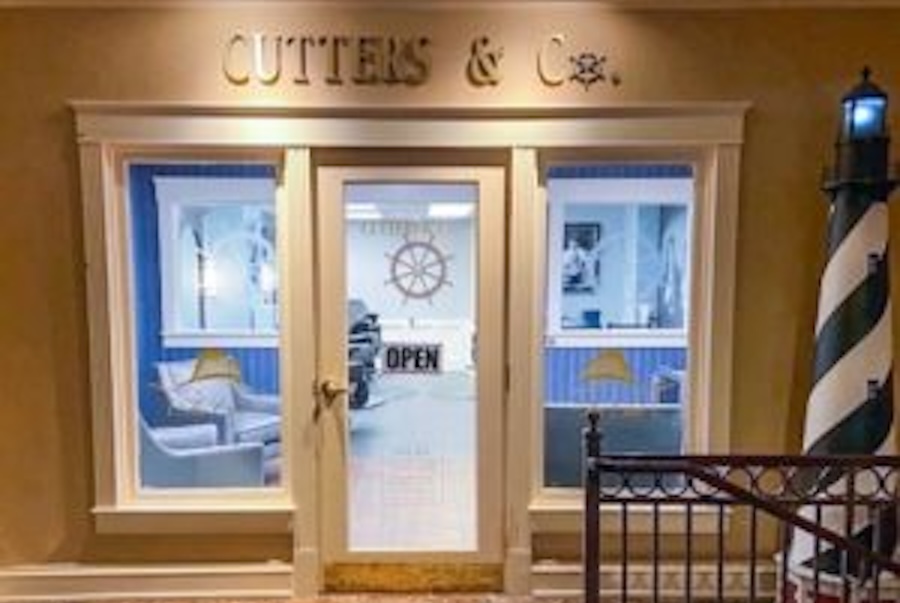 Image of a storefront of a barbershop that has a nautical theme
