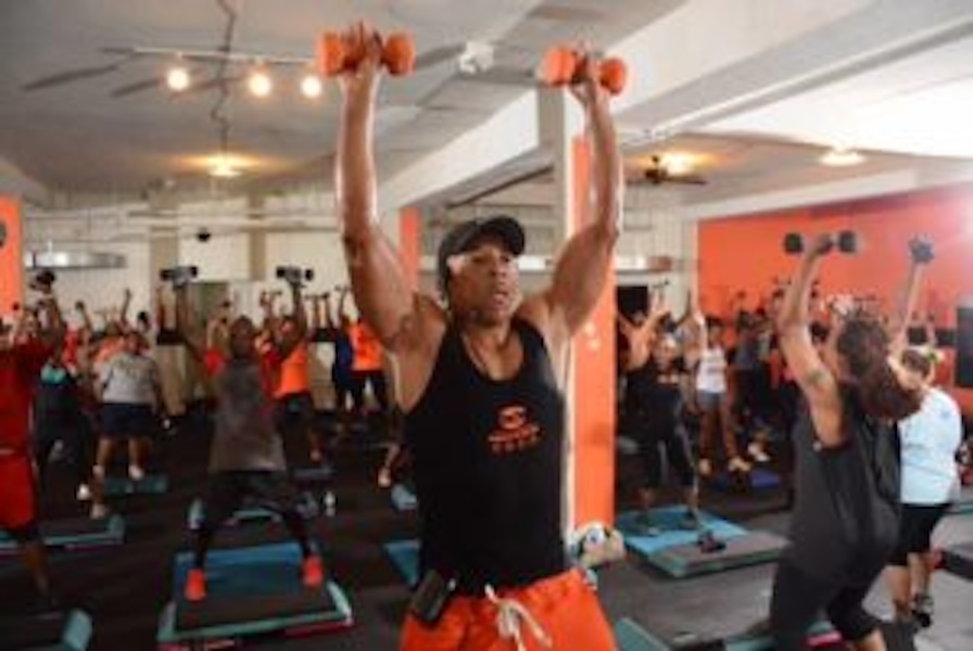 Image of a man leading a workout class with weights