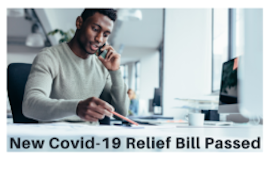 Image of a man working at a desk that reads Covid-19 Relief Bill Passed