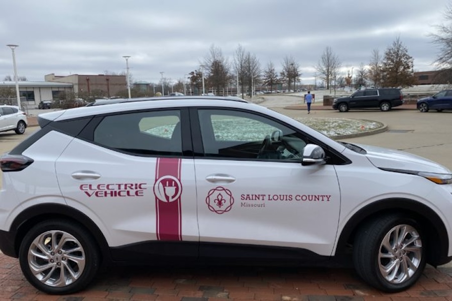 A white SUV with the Electric Vehicle logo on it and the Saint Louis County Missouri logo.