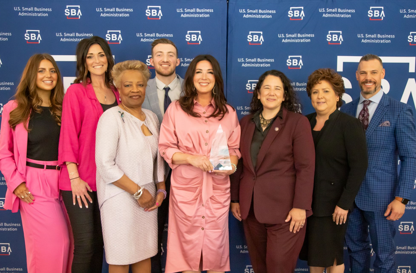 Group of people posing for a picture holding an award at the U.S. Small Business Administration event.