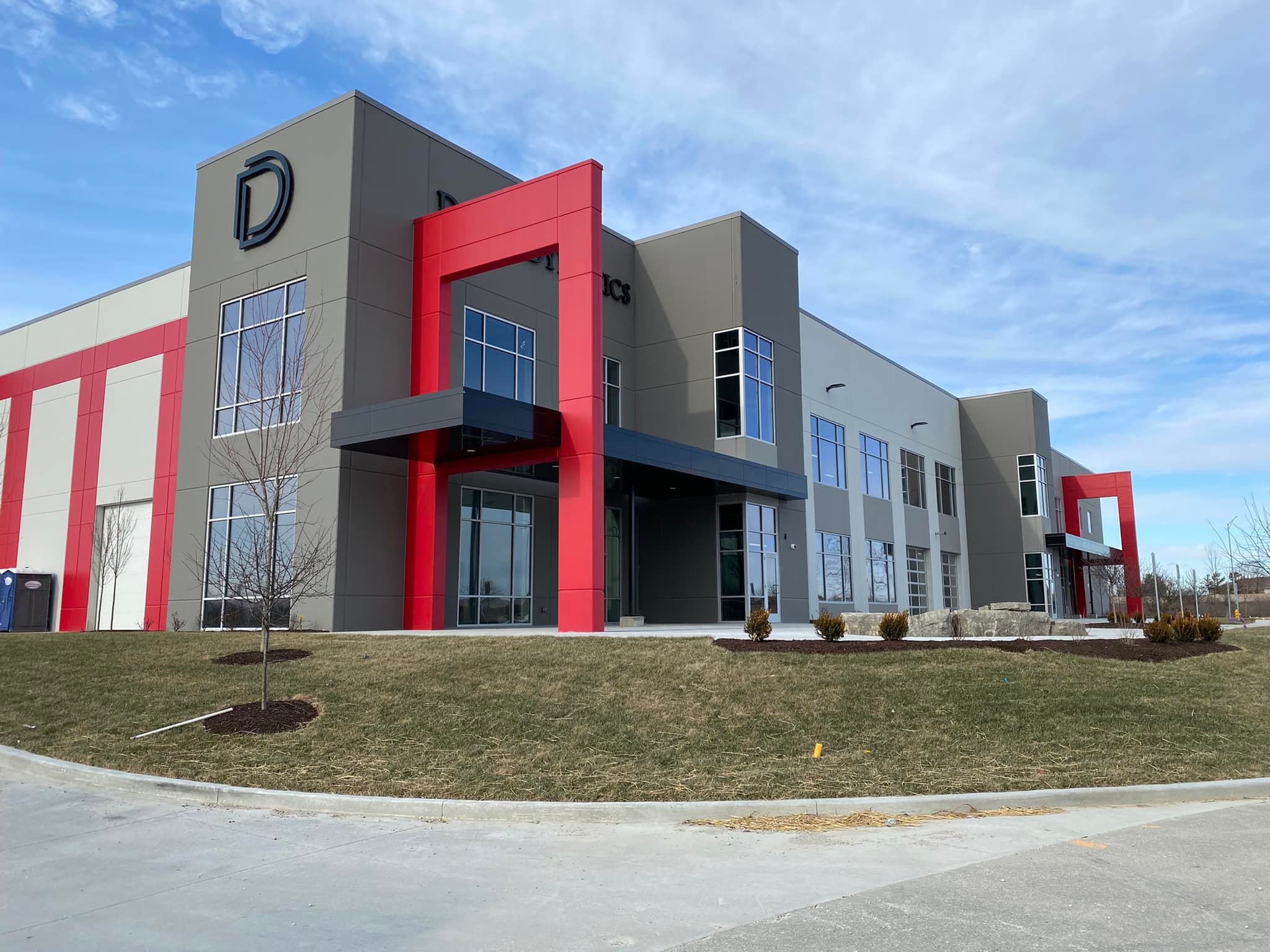 Exterior of a building with a Double D logo on the side and red accent arches.