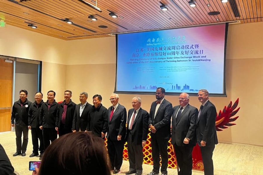 Photo of group of men standing in front of a presentation screen.