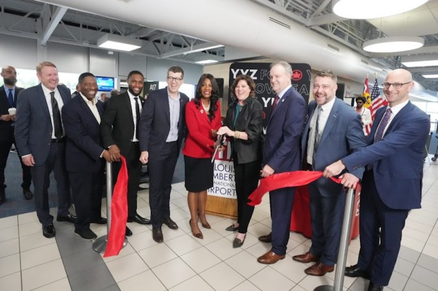 Group of people cutting a ribbon at the St. Louis airport