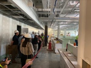 people in hard hats stand in a hallway