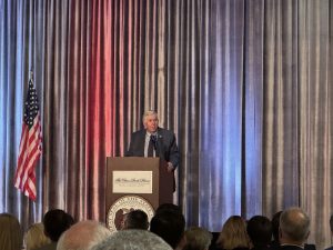 A man speaks from behind a podium