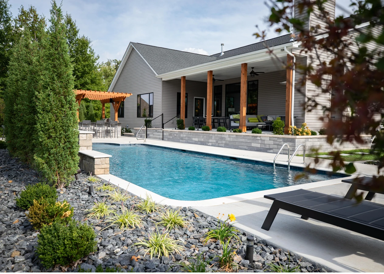 Picture of the back of a house with a pool and some shrubbery