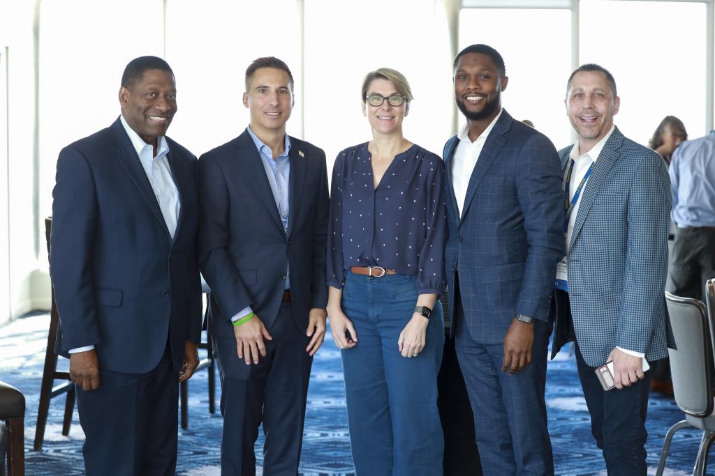 A diverse group of people stand posed for a photo