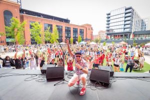 Picture of a performer kneeling in front of a crowd