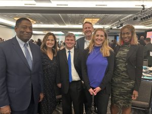 A diverse group of people stand posed for a photo