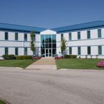 Image of a long white building with a blue roof