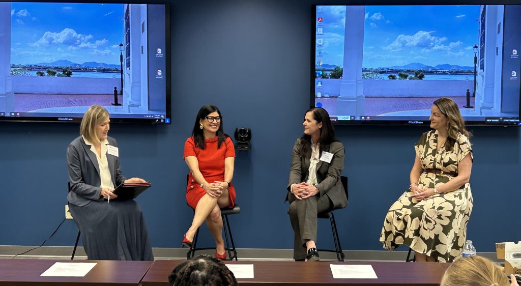 A group of women lead a panel as they sit in chairs
