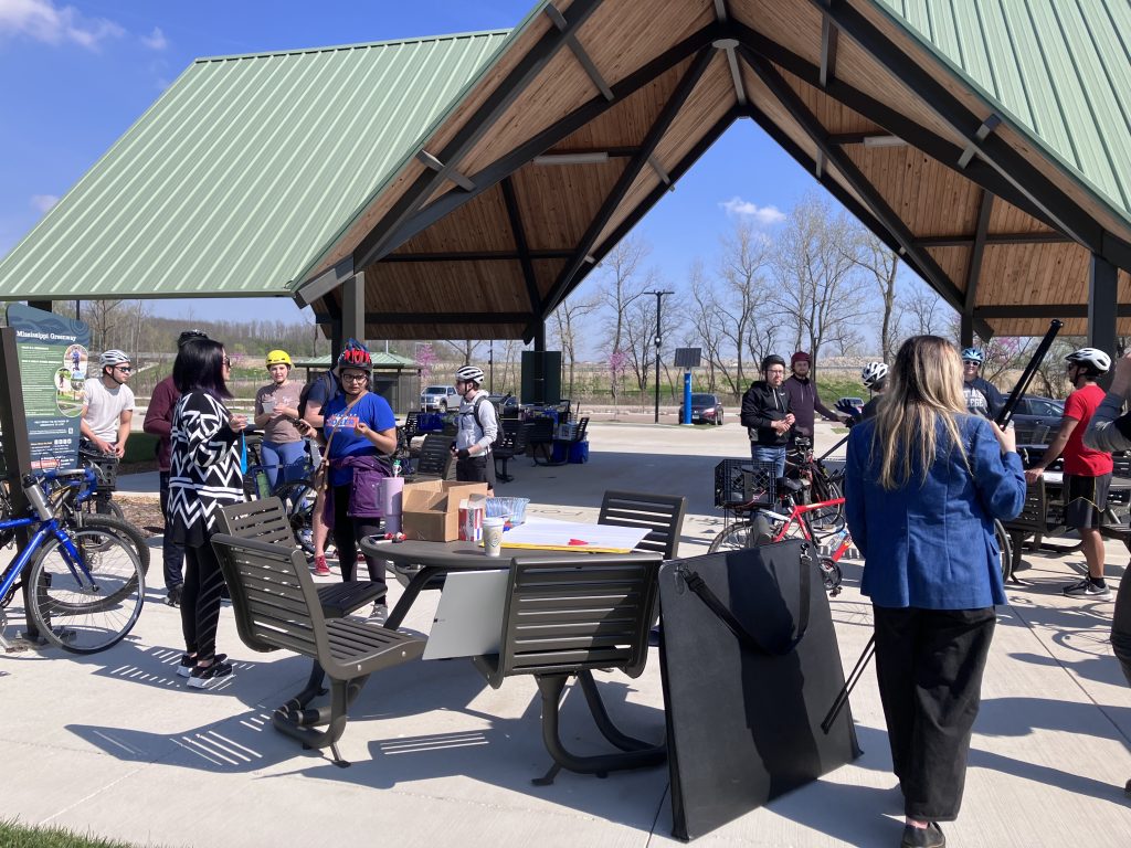 people gather to talk under a pavilion