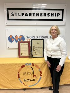 woman standing in front of two posters and a yellow table