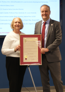 A man and a woman hold a plaque