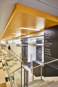 indoor shot of a hallway with stairs and a yellow ceiling