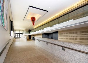 shot of a ramp in a hallway, there is a red chandelier on the ceiling
