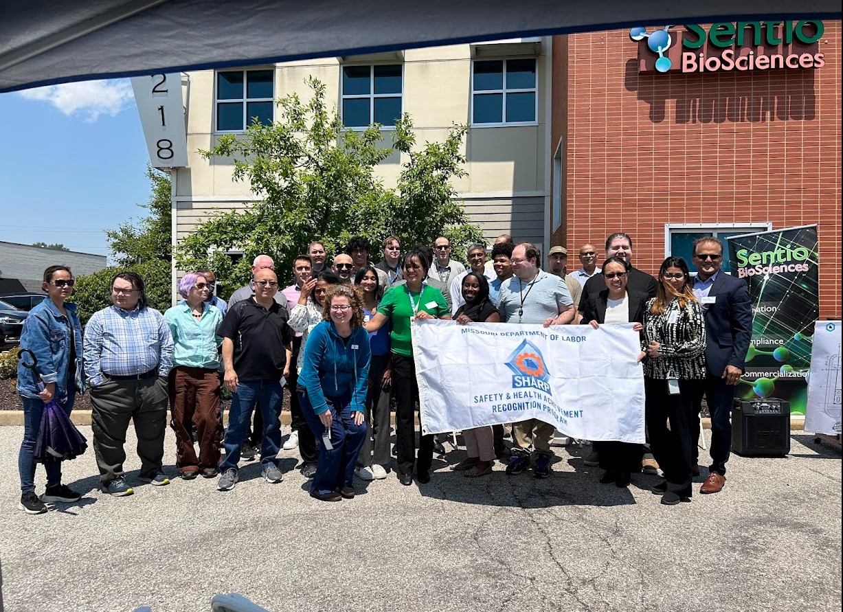 group photo of people outside, some holding banners