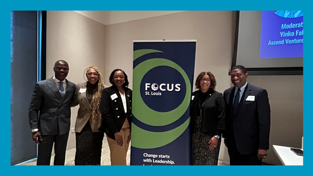 5 people stand in front of a Focus STL banner. A blue border surrounds the picture