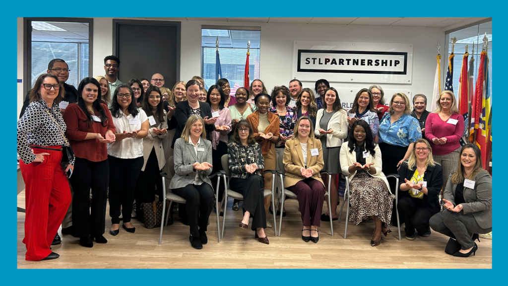 a blue border surrounds a picture of many people posing for a picture in a room