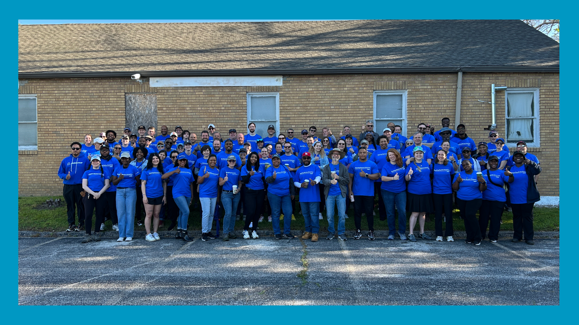 many people in matching blue shirts gather outside