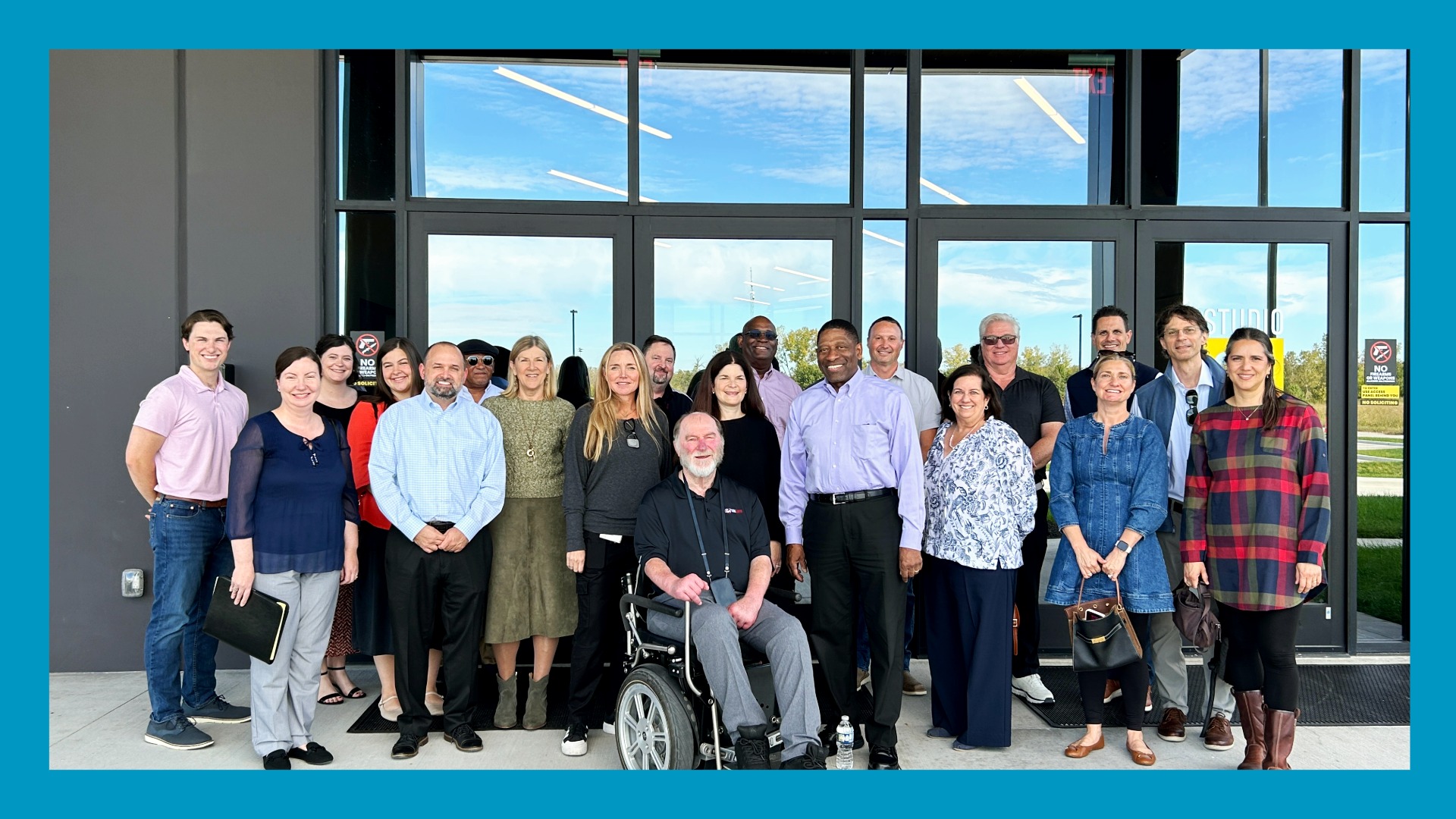 Photo of tour group outside facility with blue border around image